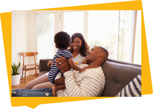 a couple sitting in their new home with their toddler 